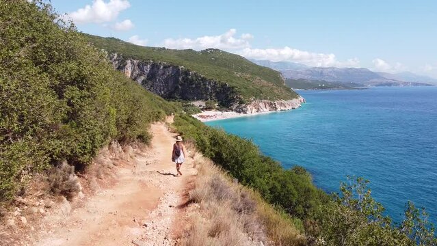 Tourist Girl walks to Beautiful Gjipe Beach in Albania - Aerial Dolly Follow