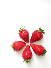 five fresh ripe red strawberries in the shape of a flower on white background