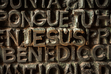 the entrance door of the sagrada familia in barcelona is characterized by all words about christianity. In this photo closeup of the word Jesus