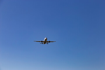 Airplane flying on the blue sky background.