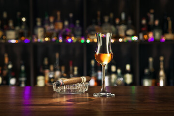 NO LOGOS OR TRADEMARKS!  SELF MADE LABELS! close up view of cigar  and a glass of rum on color back. 