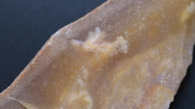 Very ancient stone, archeology material macro shot with rotating motion. Old flint stone from geological study.
