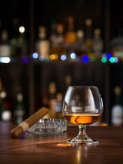 close up view of cigar and glass of whiskey on color back. 