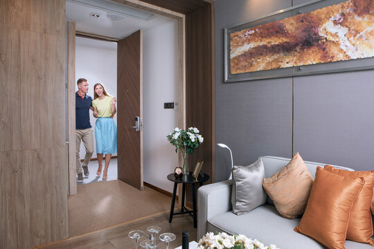 portrait of nice young couple is  entering   in condo environment