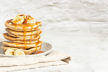 Wholegrain pancakes with banana and caramel sauce. Delicious breakfast.