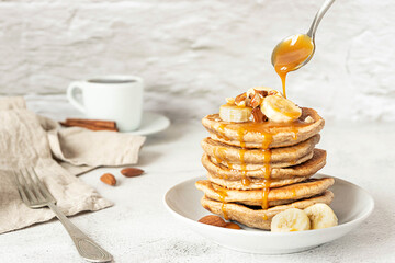 Wholegrain pancakes with banana and caramel sauce. Delicious breakfast.