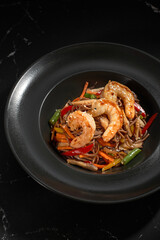 Soba shrimp and vegetables, Buckwheat noodles on a dark stone background. Asian cuisine, Wok menu.