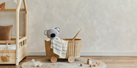 Stylish composition of cozy scandinavian child's room interior with bed, rattan basket, plush and wooden toys and textile hanging decorations. Creative wall, carpet on the floor. Copy space. Template. © FollowTheFlow