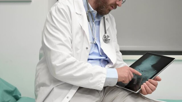 Doctor examine an x-ray image of a patient in digital tablet at doctor office. High quality 4k footage