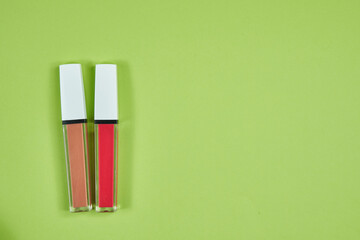 Two lipstick pink brown pattern on green background isolation