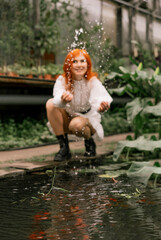 Red-haired girl walking in a tropical garden