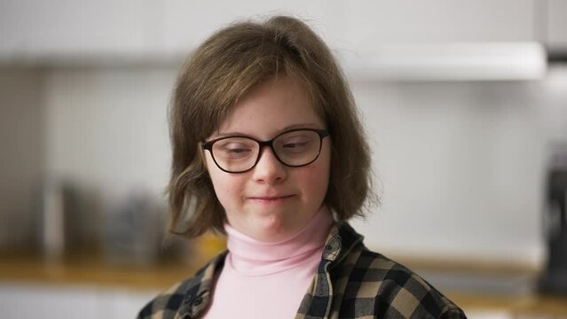 Cheerful kid smiling at camera at home. A person with special needs