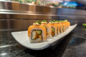 sushi with sauce on salmon roll served on a plate