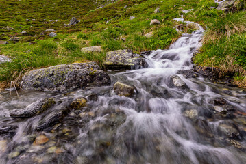 Naklejka na ściany i meble A small waterfall flowing into Oberbergbach river in austrian Stubai alps 