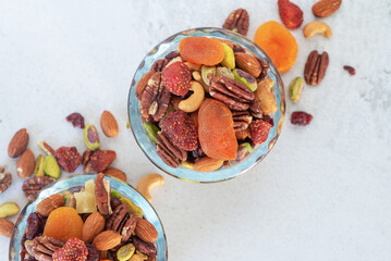 mixed nut and dried fruit in glass bowl on white table background..