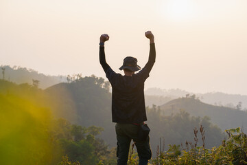 silhouette hiker man relax on mountain with sunset background