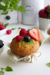 Muffin with fresh berries on the table with strawberries, blueberries, raspberries and mint close up