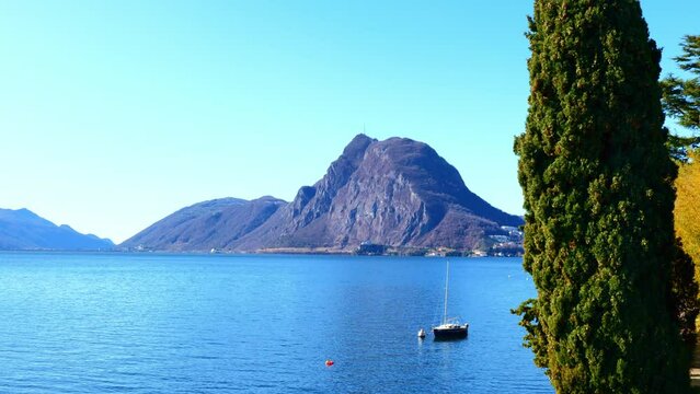 Waterfront on Lake Lugano with Mountain Peak Monte Bre and Trees in a Sunny Day with Clear Sky in Lugano Ticino, Switzerland.
