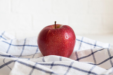 Pure tasty sweet apple in water drops on a towel