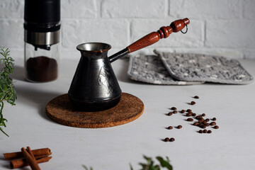Coffee making. Cezve and coffee grinder on table with coffee beans and cinnamon Turkish coffee