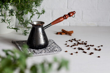 Cezve on a white table. Coffee beans