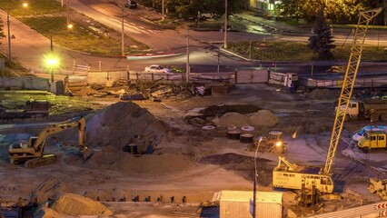 Aerial view of large road construction site with several industrial machines night timelapse.
