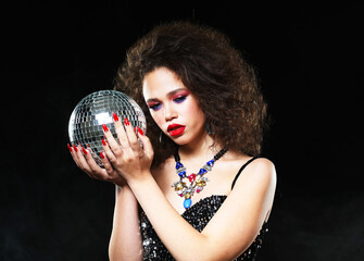 Naklejka premium Portrait of young beautiful african woman with bright make up holding disco balls