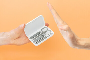 Man refusing stainless steel nail cutter set on a yellow background. Cosmetic Equipment. Cosmetic....