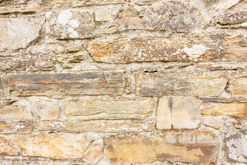 Closeup, rustic natural stone wall as background, textures, concepts, copy space.