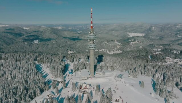 4K Aerial winter view of Rhodope Mountains and Snezhanka tower near resort of Pamporovo, Smolyan Region, Bulgaria