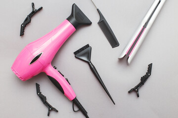 various hairdressing tools like hair dryer, comb on a gray background. beauty salon concept