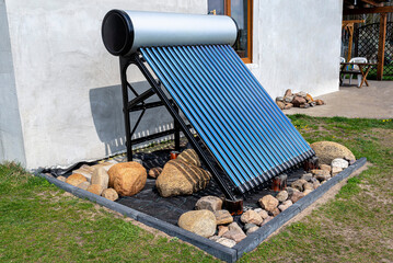A modern solar pressure collector to heat domestic hot water, standing in front of the house on the lawn. © Michal