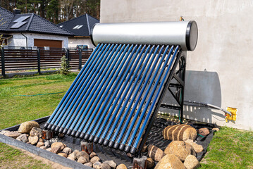 A modern solar pressure collector to heat domestic hot water, standing in front of the house on the...