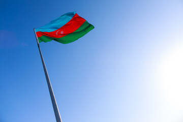 Fototapeta na wymiar Azerbaijan flag waving on blue sky background