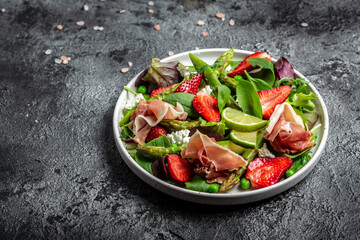Healthy salad. green asparagus, strawberry, rocket and cottage cheese. Healthy balanced eating. Top view