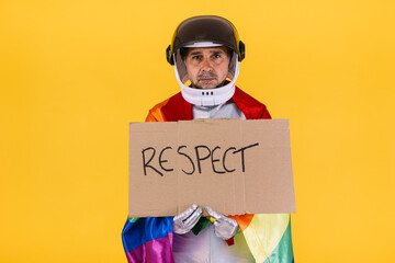 Gay man dressed as an astronaut with a helmet and silver suit, with the flag of the lgtbi...
