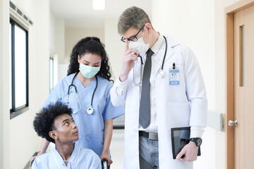 Obraz premium Doctor talking to a patient in wheelchair at hospital