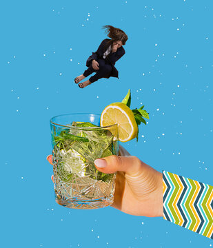 Contemporary art collage. Young woman jumping into cocktail, mojito isolated over blue background