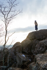 Woman standing on high rock (vertical)