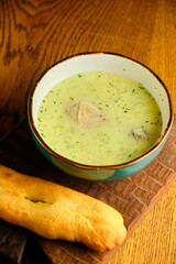 Peas soup in the yellow bowl on the wooden background.