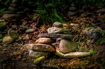 Fototapeta premium Setting Sun lights the Cairns stacked along the trail at Watkins Glen State Park in Upstate NY 
