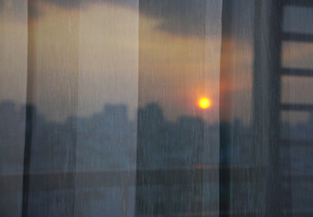 Golden sunset over Ho Chi Minh city reflection on an apartment window glass