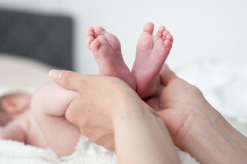Obraz na płótnie Canvas Baby feet in mother hands. Mom and her Child. Happy Family concept. Beautiful conceptual image of Maternity