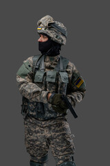 Fototapeta premium Shot of ukrainian infantry dressed in protective costume holding pistol isolated on gray background.