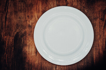 white empty plate on a wooden table