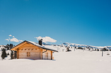eine Bergh&uuml;tte, Holzhaus im Schnee in Landschaft bei blauer Himmel in den Bergen