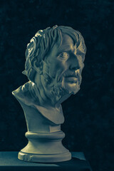 Colorful gypsum copy of ancient statue of Lucius Seneca head for artists on a dark textured...