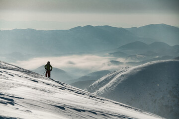 man skier in a ski suit stands and looks to the side © fesenko