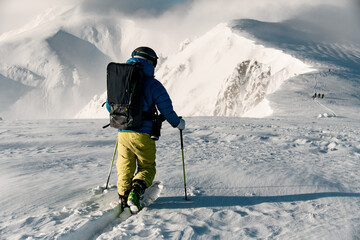 Fototapeta na wymiar Man skier wiith ski equipment making his way through the untouched snow
