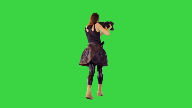 Cyberpunk girl in black military clothes walks with machine gun, taking an aim on a Green Screen, Chroma Key.